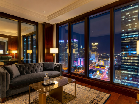 Luxurious hotel penthouse views looking out onto glowing downtown city blocks